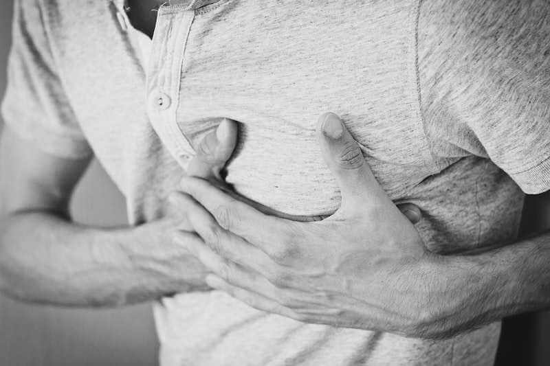 person with hands on chest in pain