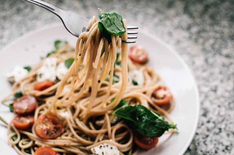 pasta dish with basil on a white serving plate 