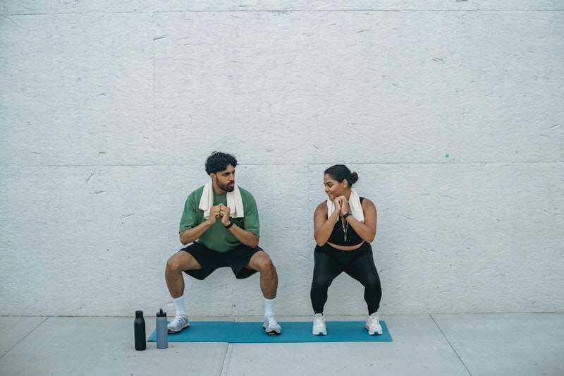 man and woman doing wall sits for fit legs