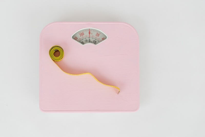 tape measure on a pink weighing scale