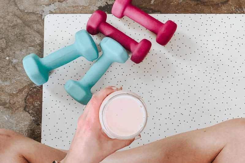 glass of fitness drink and dumbbells