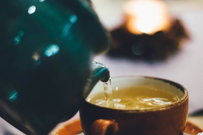 pouring tea on a ceramic tea cup