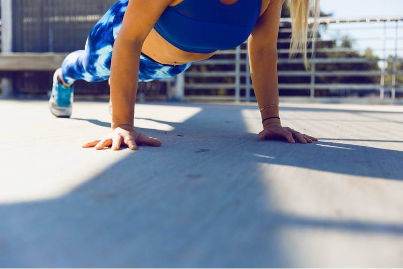 woman in blue sports wear doing push ups