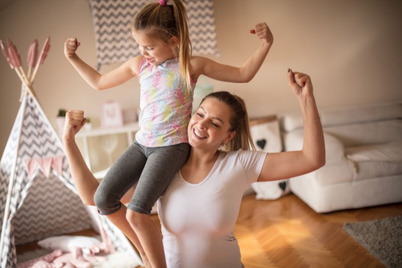 mom carrying her daughter in her shoulder